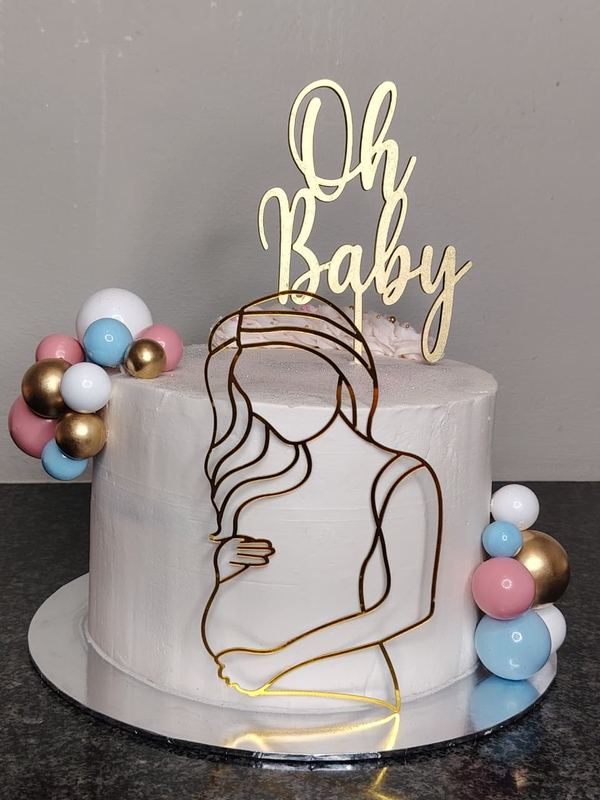 White Oh Baby baby shower cake with gold silhouette topper and pastel spheres