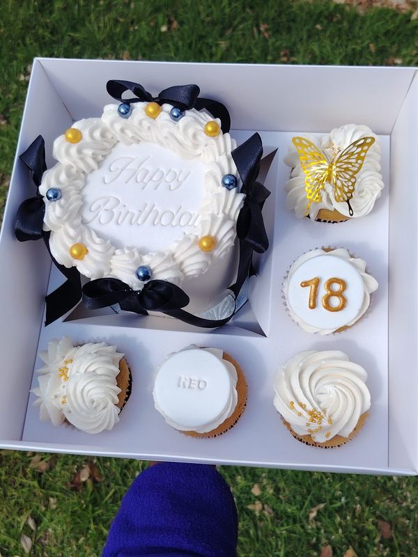 Happy Birthday bento cake with navy bows and matching 18th cupcakes in a gift box