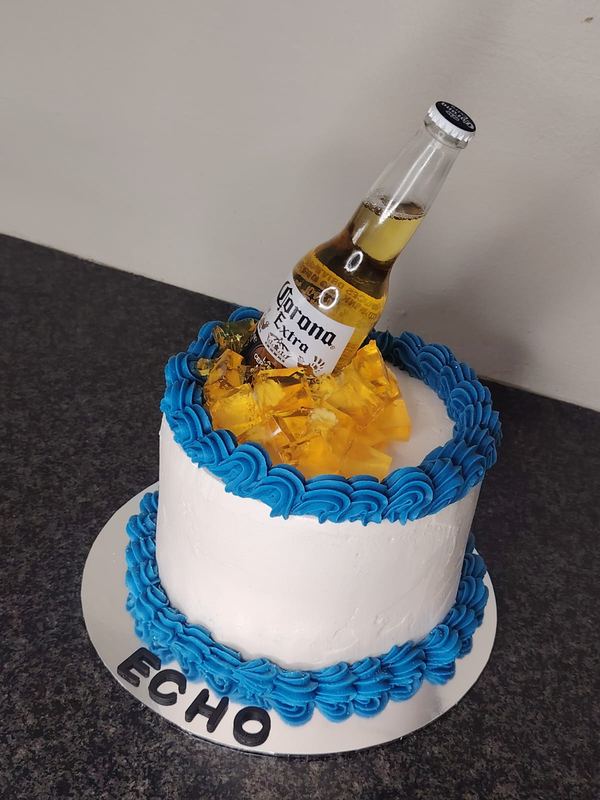 White and blue ice-bucket birthday cake with a beer bottle topper