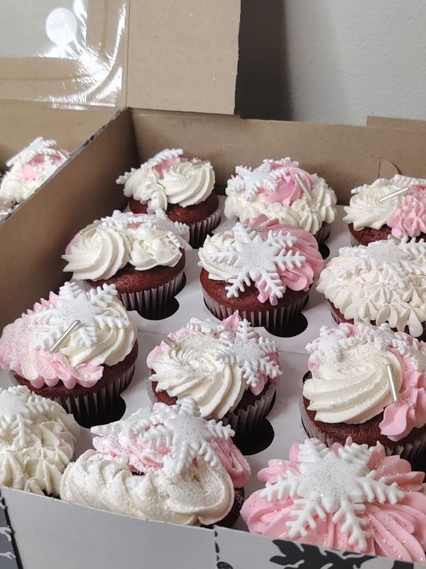 Red velvet cupcakes with pink and white swirls and snowflake toppers