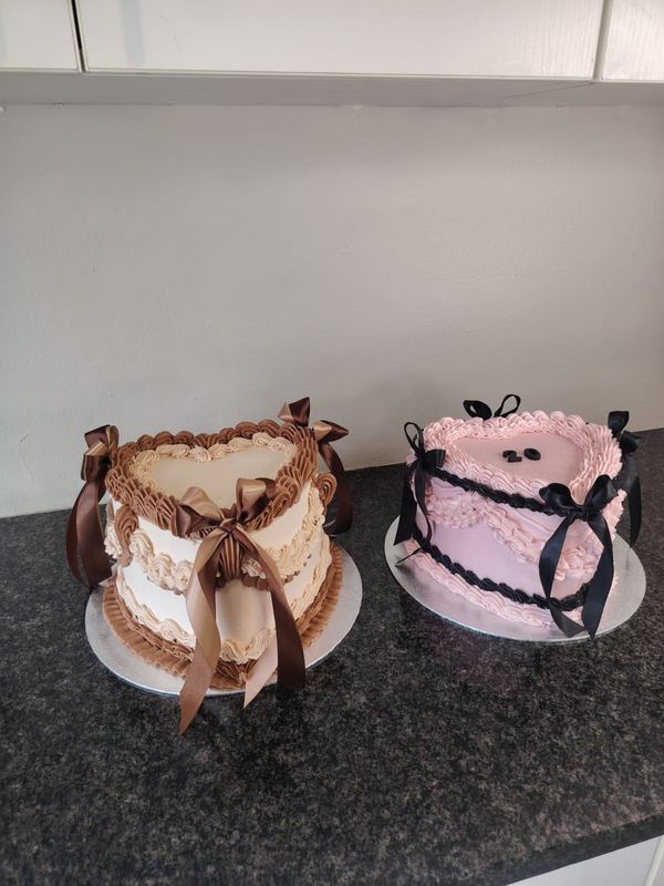 Two vintage heart cakes, one brown and one pink, with ribbon bows