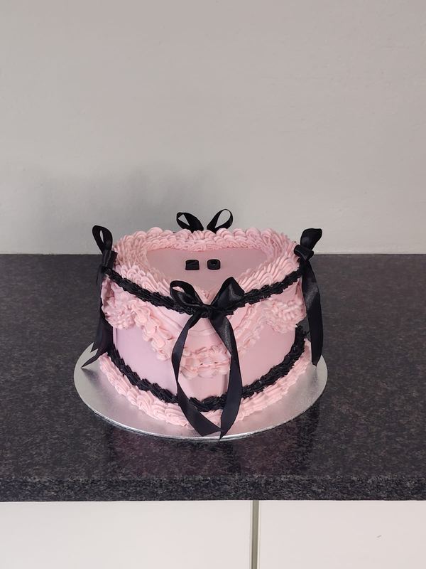 Pink heart cake with black piping and black bows