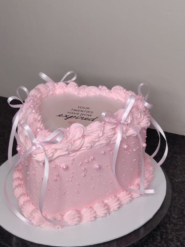 Pink heart cake with pearls and ribbons
