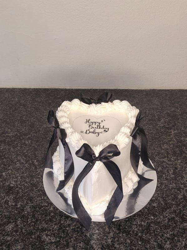 White heart birthday cake with black bows